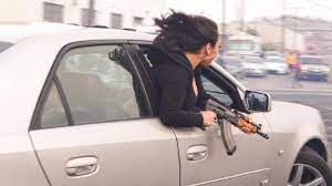  Woman Captured In A Photo Leaning Out Of A Vehicle Holding An AK-47 In San Francisco